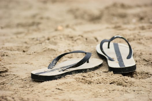 a pair of slippers at the beach