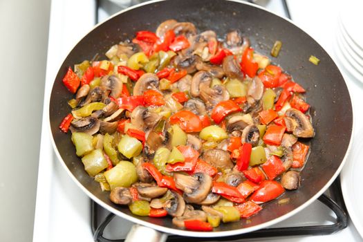 Marinated Mushrooms with Red Bell Peppers in a frying pan.