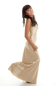 A happy young woman wearing a long gold silk dress   White background.