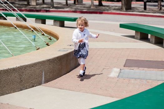 Having fun running around the fountain in the park.