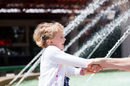 Having fun running around the fountain in the park.