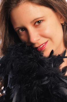 attracive young woman with a bunch of black feathers