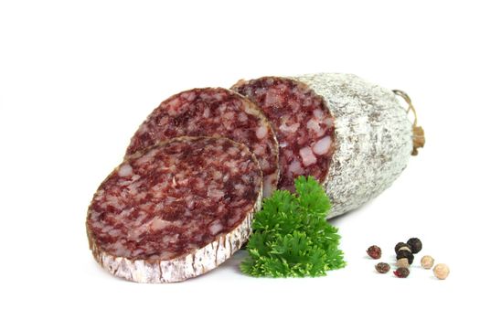 Salami with peppercorns and fresh parsley on a white background