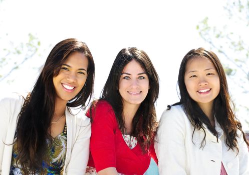 Group of three diverse young girlfriends smiling