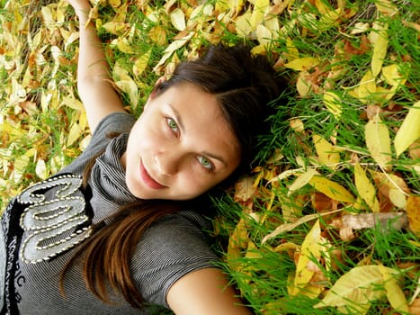 The young fine girl has a rest in warm autumn park