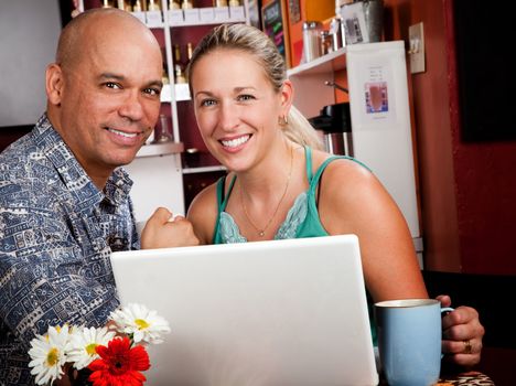 Attractive couple in a coffee house with laptop computer