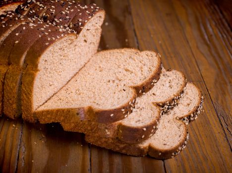 Slice of fresh wholemeal bread, on wooden table, studio shot.