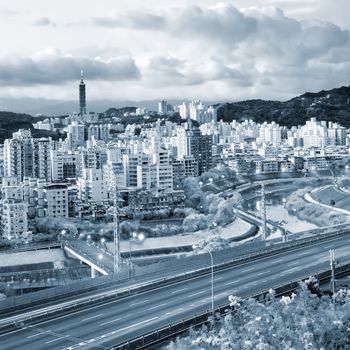 It is a cityscape photo of apartments and highway.