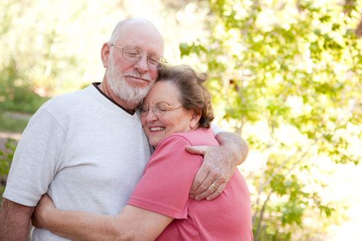 Loving Senior Couple Hugging Enjoying the Outdoors Together.