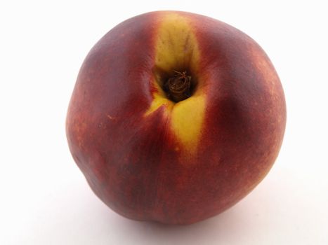 A ripe red peach isolated against a white background.