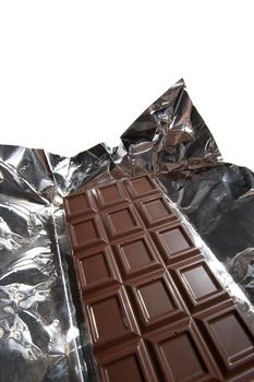 Dark chocolate in a foil on a white background