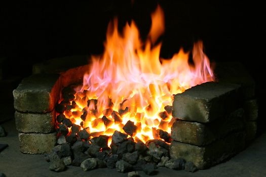 Burning black coal in the forge imposed by a brick