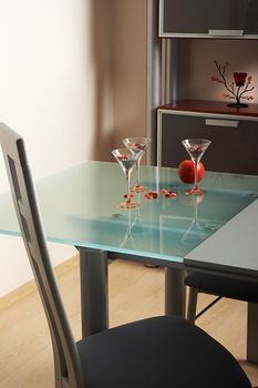 Three glasses and apple on a table in modern kitchen