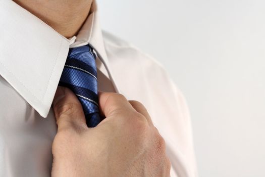 Business man tying a tie
