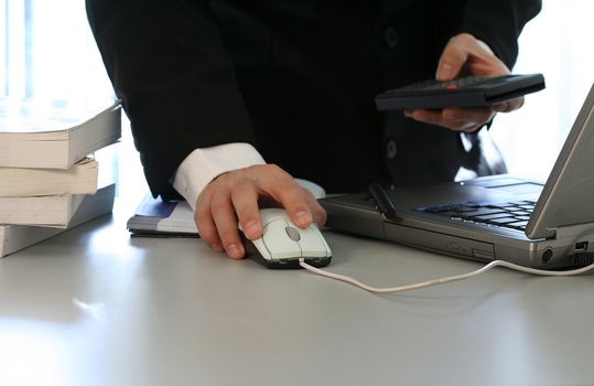 Businessman with laptop and calculator