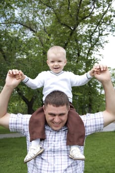 father playing with baby, raised it high above them