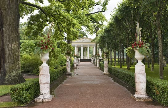 The way with vases in the garden leading to classical pavilion