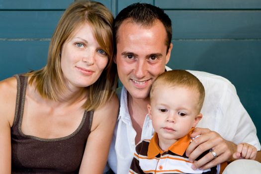 Happy perfect young family with dad, mom and son outdoors having fun