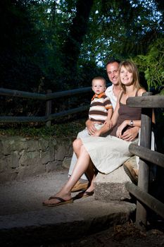 Happy perfect young family with dad, mom and son outdoors having fun