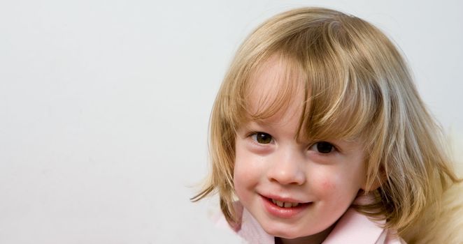 Cute young caucasian boy with blond hair smiling with copy space