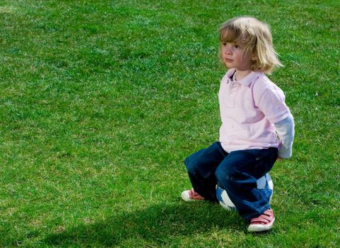 Cute young caucasian boy playing football or soccer outdoors