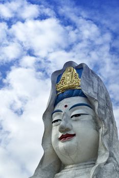 Guanyin statue with a white clouds background 
