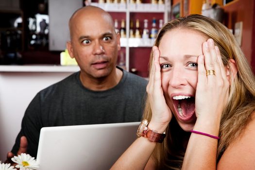 Bored woman with man on laptop computer in coffee house