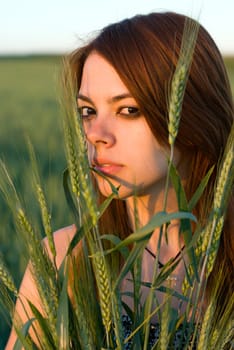 Young woman holding cereal crops in a field