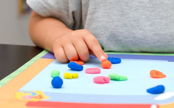 Baby hand and colored plasticine