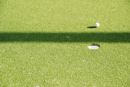 photo of a beautiful green golf ball in front of the hole