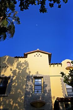 A half moon rises over an art-deco building in Miami, Florida.