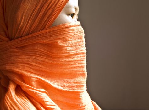 Close-up of a Islamic woman covered with a orange veil 