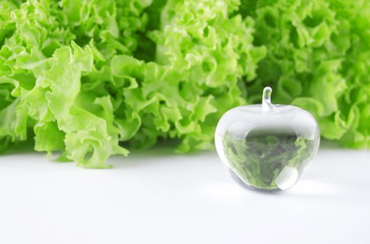 Concept photo of a crystal apple and fresh lettuce