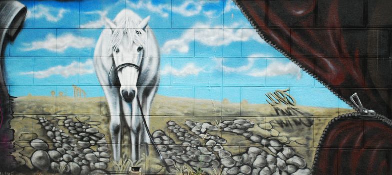 a graffiti with a horse on a wall
