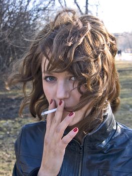 pretty girl smoking in the park in sunny day