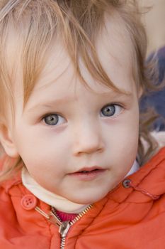 little girl wiyh curious eyes in orange dress