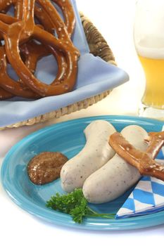 White sausage with sweet mustard and pretzels on a white background