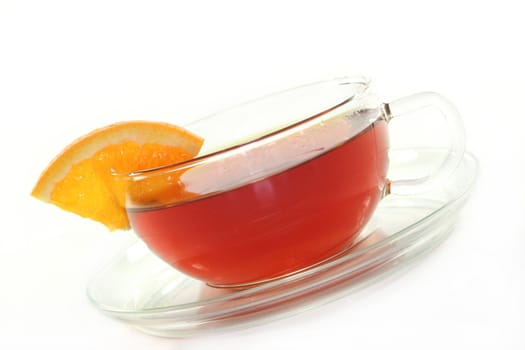 a cup of orange tea with fresh oranges
