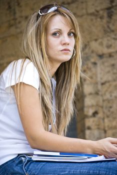 beautiful young woman with books and flower outdoor