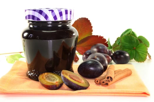 a glass of plum jam with autumnal decorations