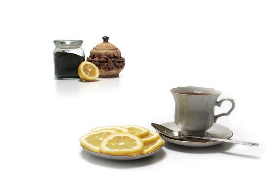 Tea with a lemon on a background a sugar bowl and a tea leaf.