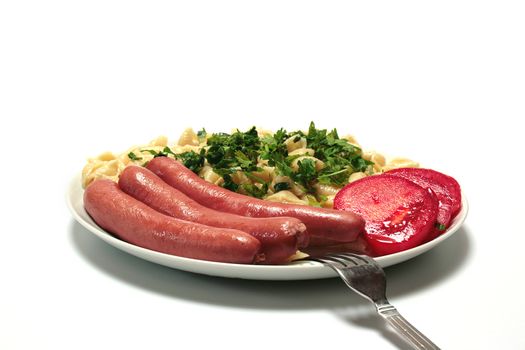 Vermicelli with sausages with parsley and the cut tomato in a plate.