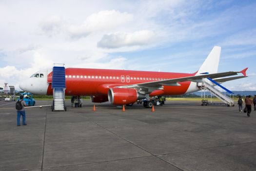 Image of red passenger airliner at Yogyakarta, Indonesia.