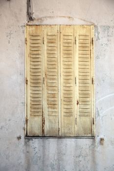 Closed yellow shutters and worn dirty building