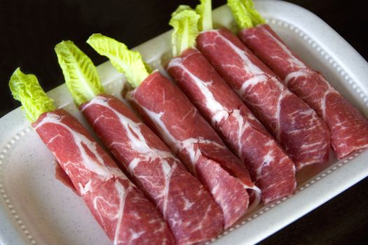 Image of raw sliced lamb rolls.