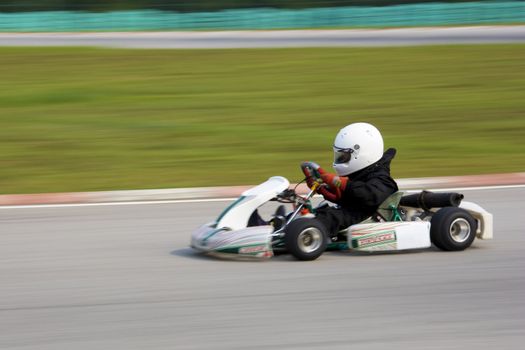 Image of a go-kart racer competing at the KKS-AAM Malaysian Kart Championship 2009, held at Sepang International Karting Circuit, Sepang, Selangor, Malaysia on 7 June, 2009. Image intentionally taken with motion blur to portray speed.