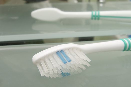 two tooth brushes on glass table