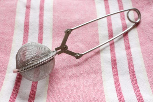 A tea infuser on a textile background