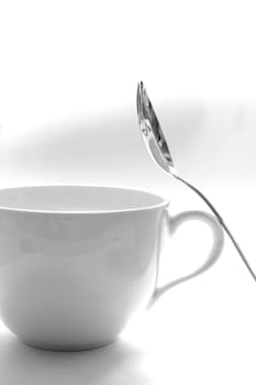 A cup and a spoon on a white background