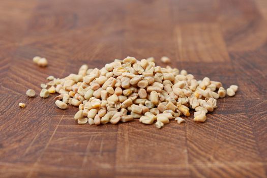 Fenugreek seeds on a brown surface